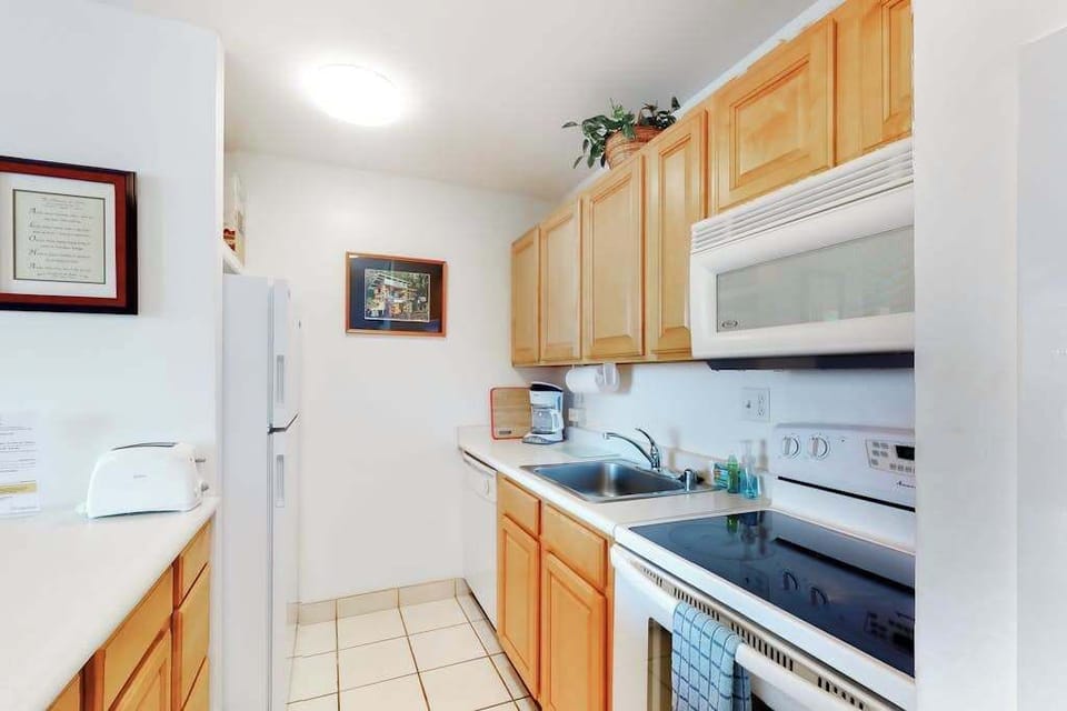 The fully equipped kitchen boasts modern appliances, including a fridge, stove, oven, and dishwasher, making meal preparation a breeze. 