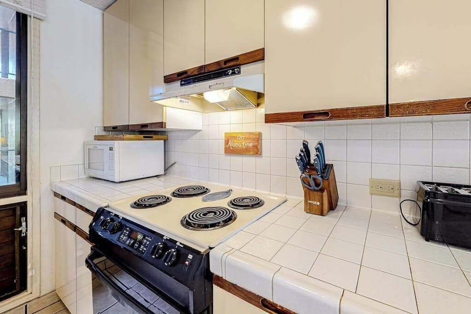 Well-equipped kitchen with ample cabinet storage, cookware, and convenient appliances