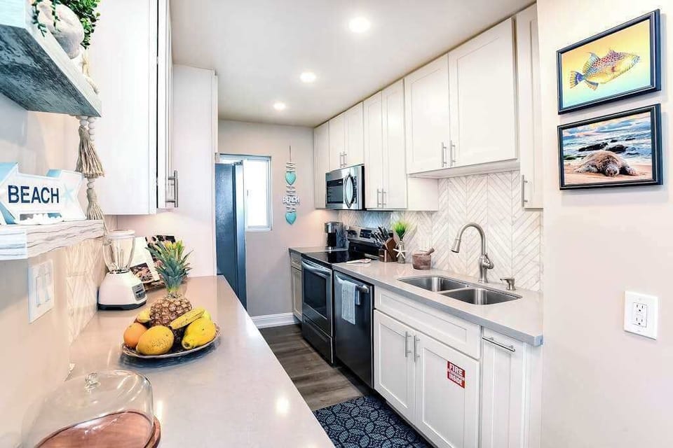Modern stainless steel kitchen with an open-concept design that flows seamlessly into the living room, making it easy to cook, gather, and stay connected.