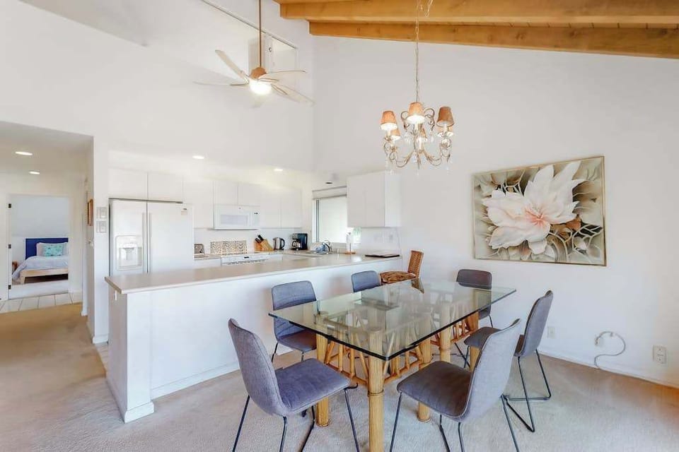 Dining table and chairs brighten open kitchen space beside windows