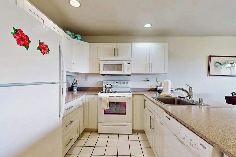 Galley kitchen counters support easy cooking beneath cheerful overhead lighting