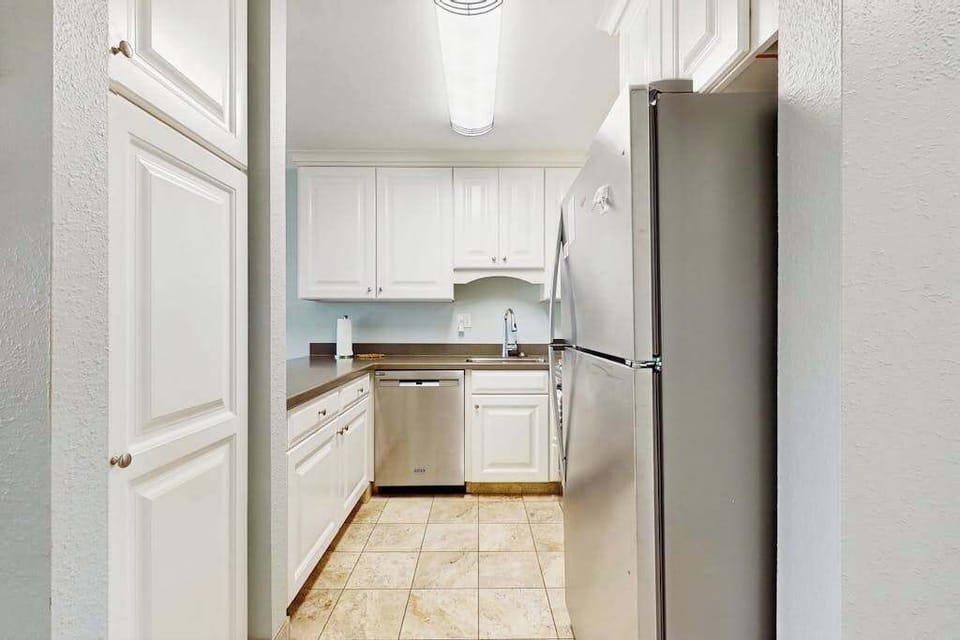Cozy kitchen with everything you need for home-cooked meals, opening to the dining and living areas with abundant natural light from the sliding doors to the lanai.