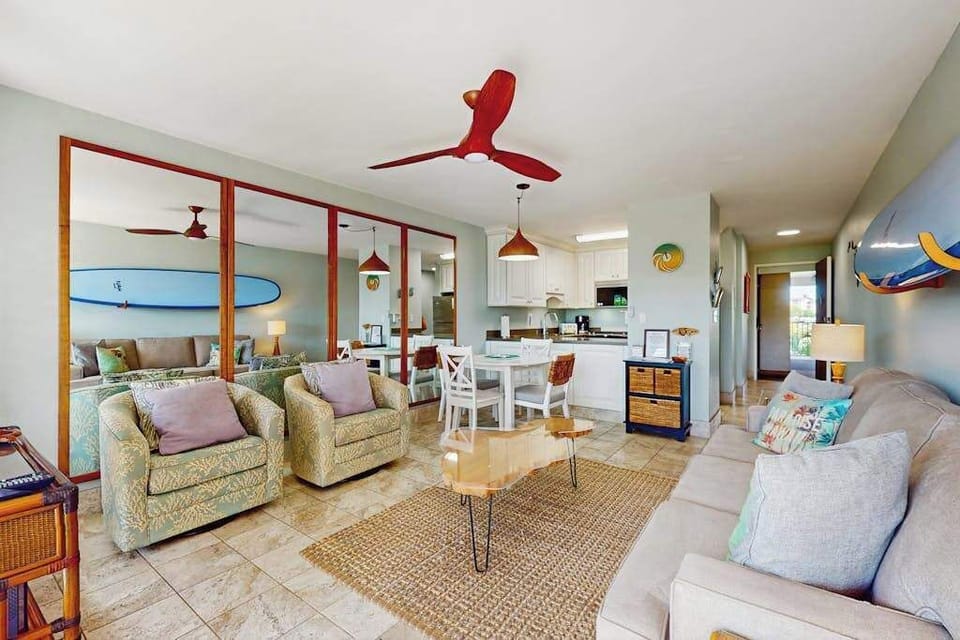 Cozy living room with surf-inspired décor, a flat-screen TV, a comfortable sofa bed, and direct access to the private lanai.