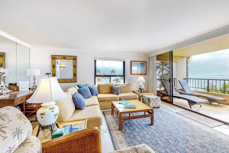 This large living room with a comfortable sectional with views from the open sliders of the lanai.  Turquoise waters as far as the eye could see.