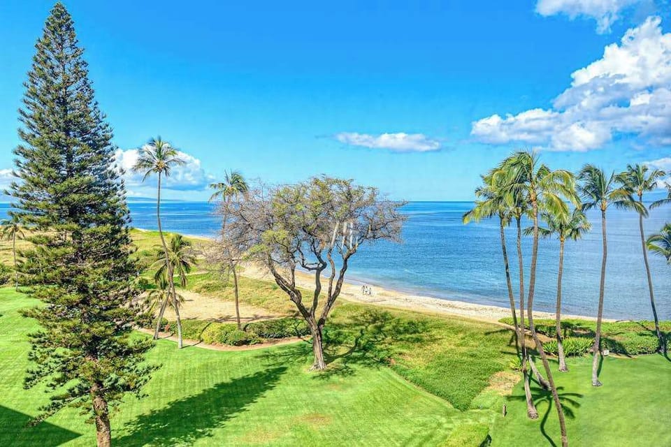 Perfectly manicured lawns with tropical foliage against the backdrop of the Pacific Ocean.