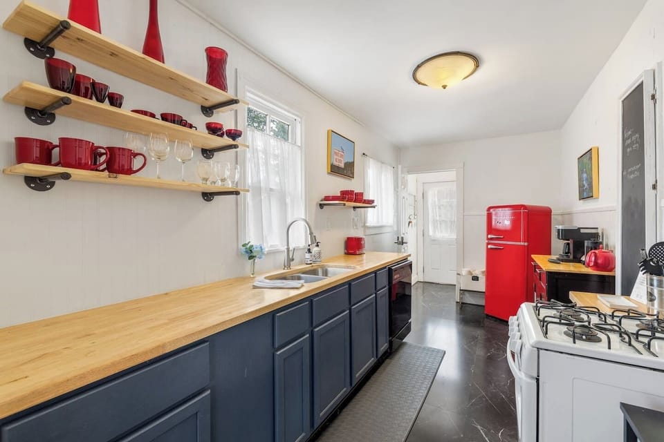 Featuring charming vintage touches, open shelving, and cheerful pops of red, this inviting kitchen is stocked with everything you need!