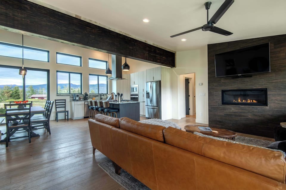 The great room delivers: soaring ceilings, a stone fireplace, and windows that frame the mountains like living art. The best seat in the valley.