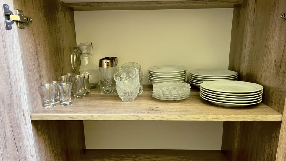 Plates, glasses, cups, and a water pitcher are provided