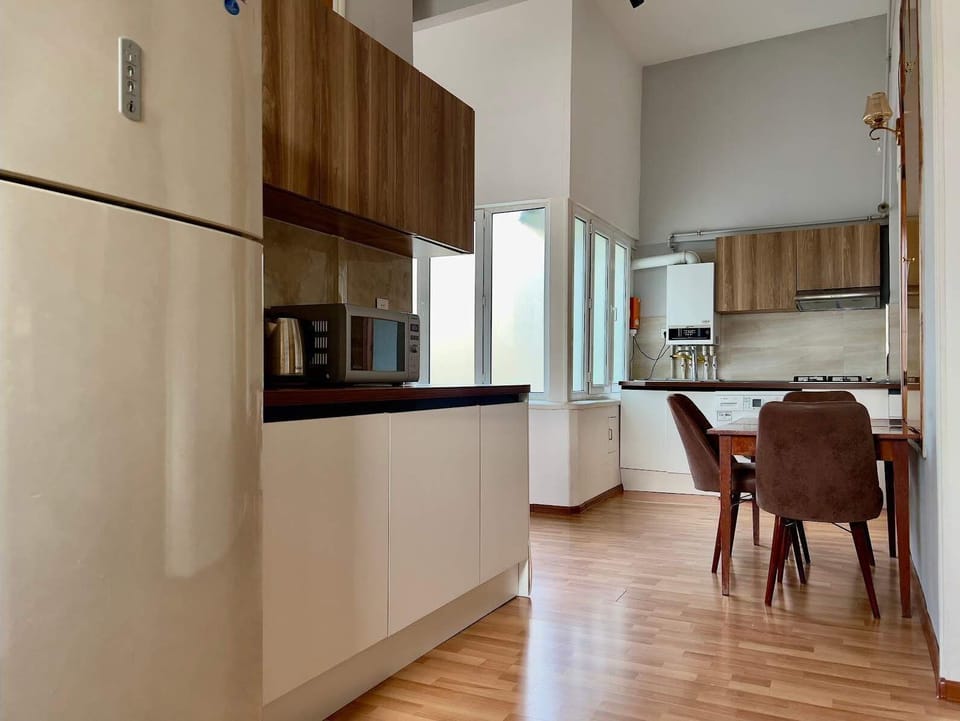 Second kitchen view with dining nook, gas hob, washer and full-size refrigerator.