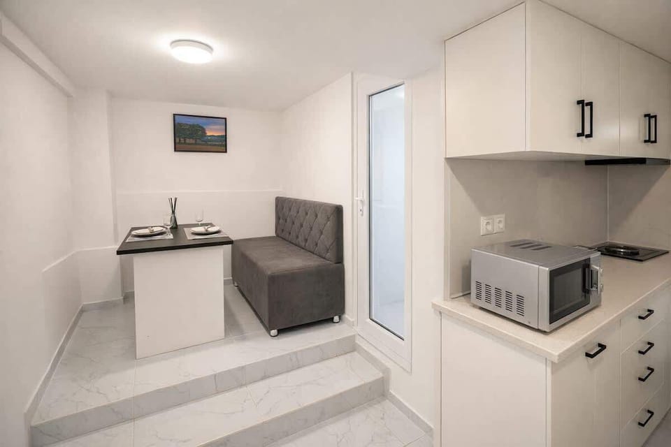 Cozy modern kitchenette with banquette dining nook for two.