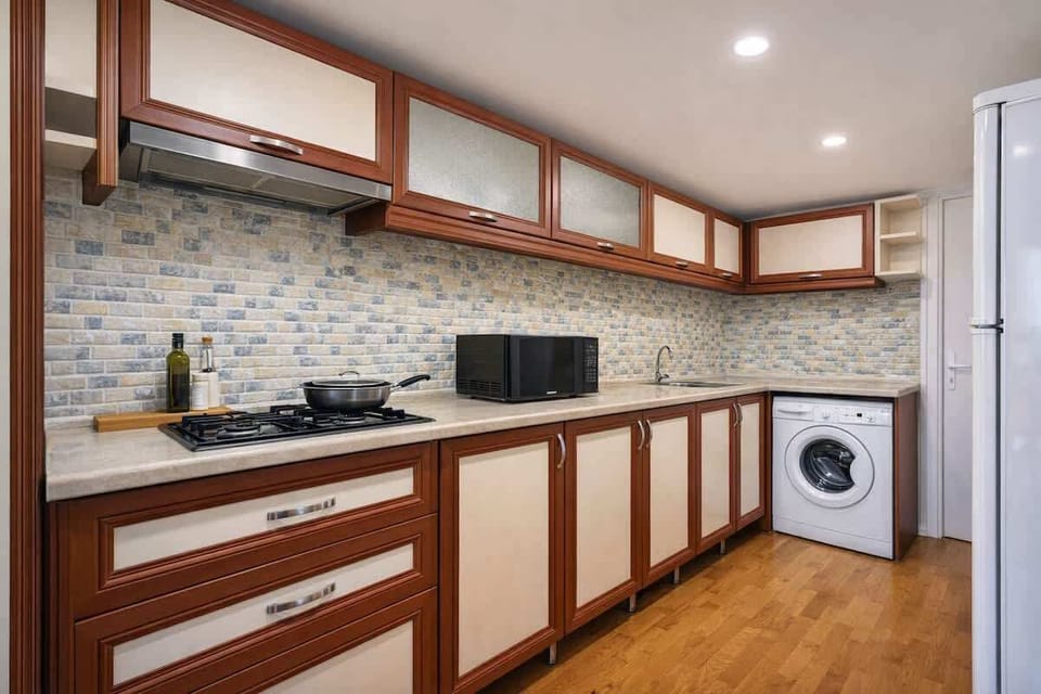 Modern L-shaped kitchen with gas hob, microwave, washer, ample storage