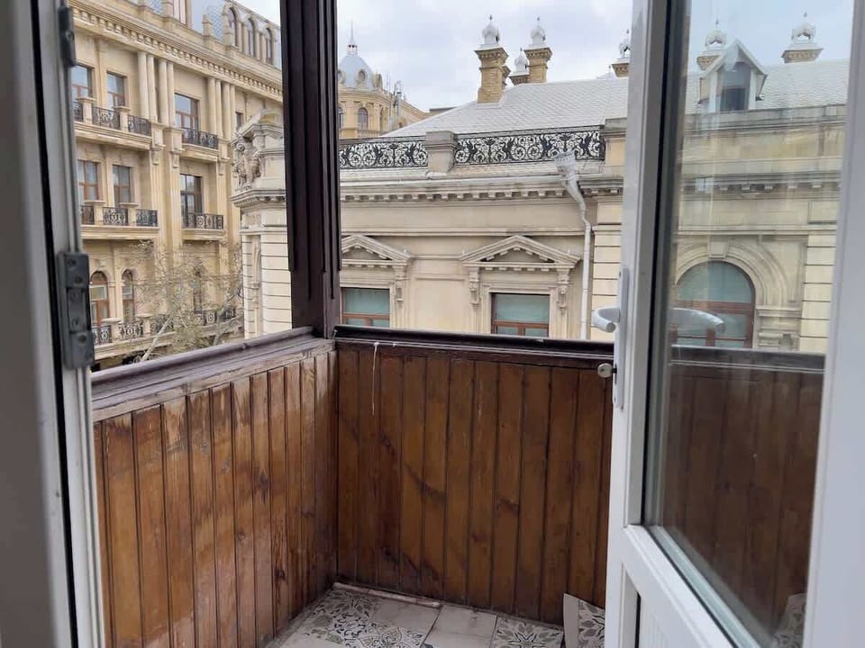 Enclosed balcony overlooking historic central Baku architecture.