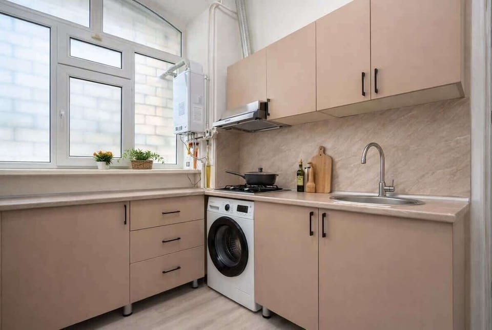 Bright modern kitchenette with gas hob and in-unit washer.