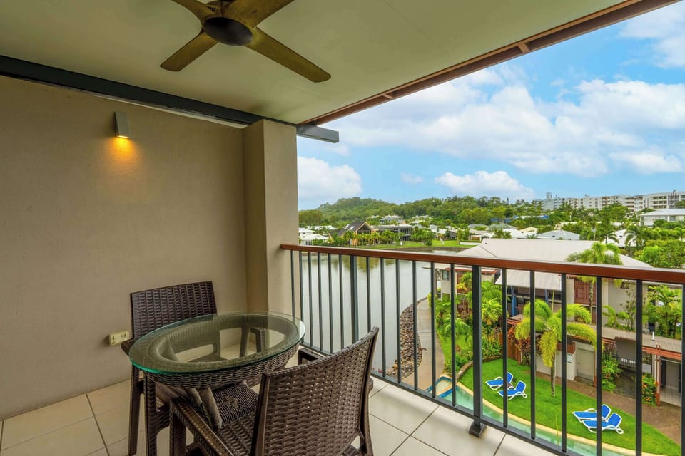 Dine alfresco on the studio balcony while taking in tranquil lagoon views and tropical surrounds, with the shared swimming pool visible below adding to the resort-style setting.