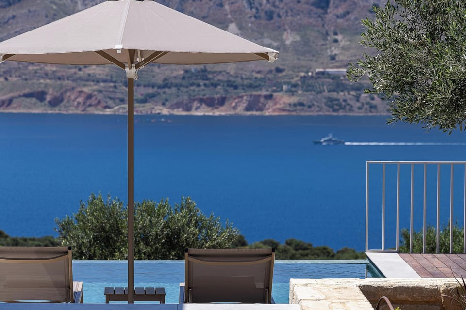 Enjoy a spacious private pool area with comfortable sunbeds and shaded spots, overlooking the stunning Souda Bay.
