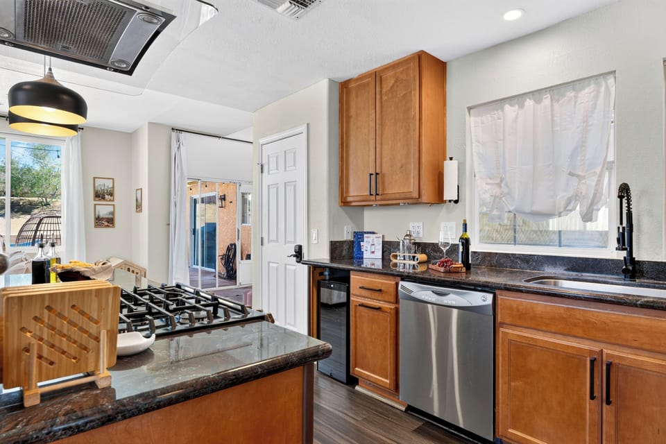The kitchen layout offers expansive meal prep areas, under-cabinet space, and direct access to the outdoor patio.