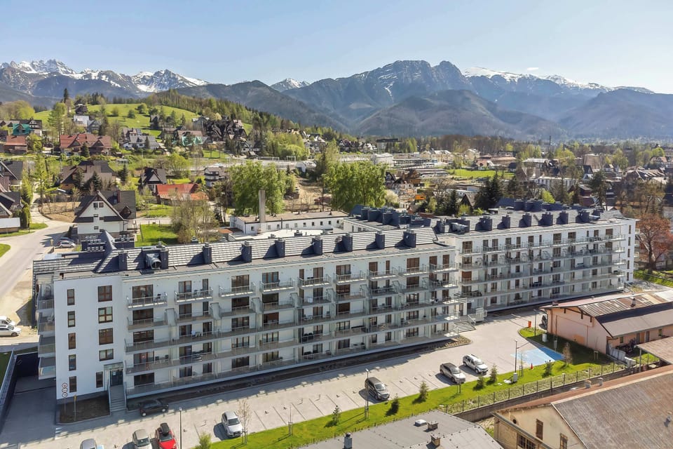 Exterior view of the apartment building surrounded by beautiful mountain scenery.