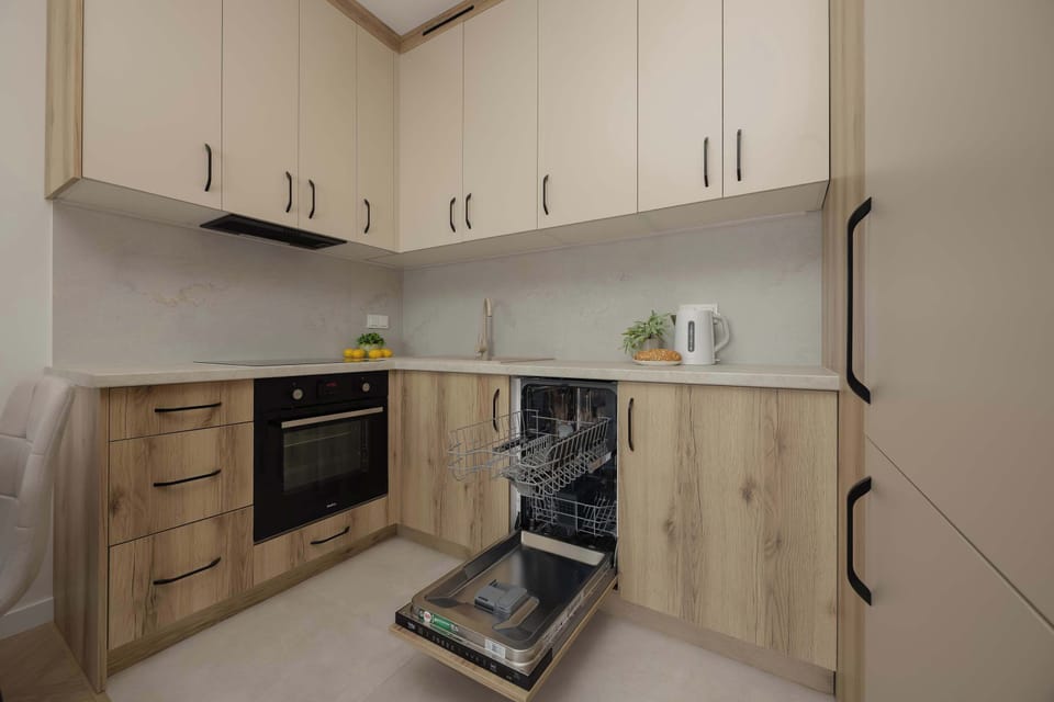 A functional kitchenette setup displays an open integrated dishwasher, showcasing the practical amenities available for guests. The seamless alignment of the appliances maintains the sleek, modern aesthetic of the cabinetry.