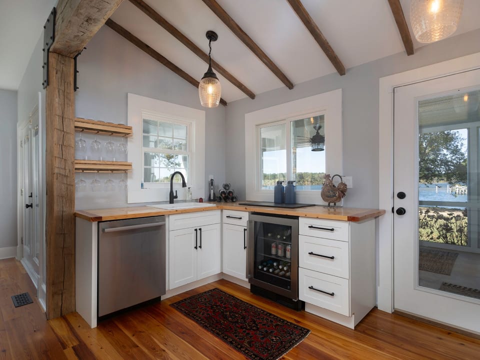 Step into your beautifully appointed kitchen with rustic wood beams, warm hardwood floors, and stunning lake views just beyond the door. Your culinary space awaits.