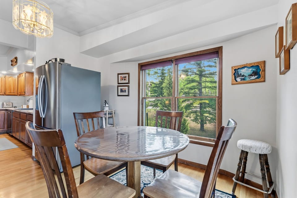 Gather around this inviting dining table where your morning coffee tastes even better with lush forest views framing every meal you share together.