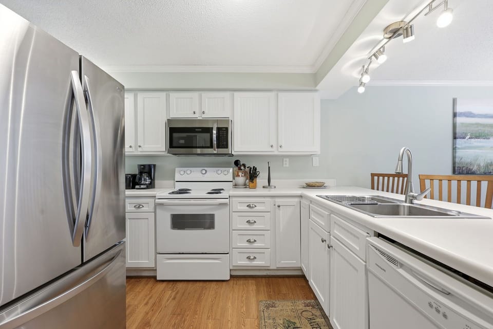 Your fully equipped kitchen features white cabinetry, stainless steel appliances, and modern conveniences—perfect for preparing home-cooked meals during your stay. Cook, dine, and gather in this bright, welcoming space.