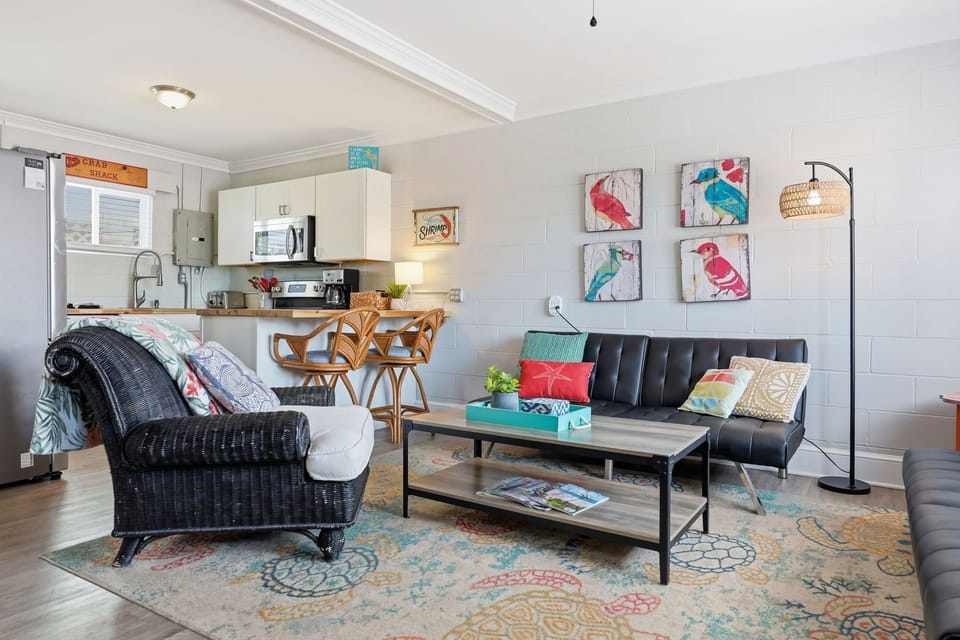 Settle into this vibrant coastal retreat where playful bird art adds personality to your open living space. The fully equipped kitchen and cozy seating invite easy, relaxed beach getaways.