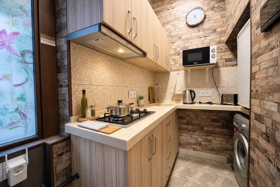 Cozy modern kitchen with cooktop, microwave, fridge & in-unit washer