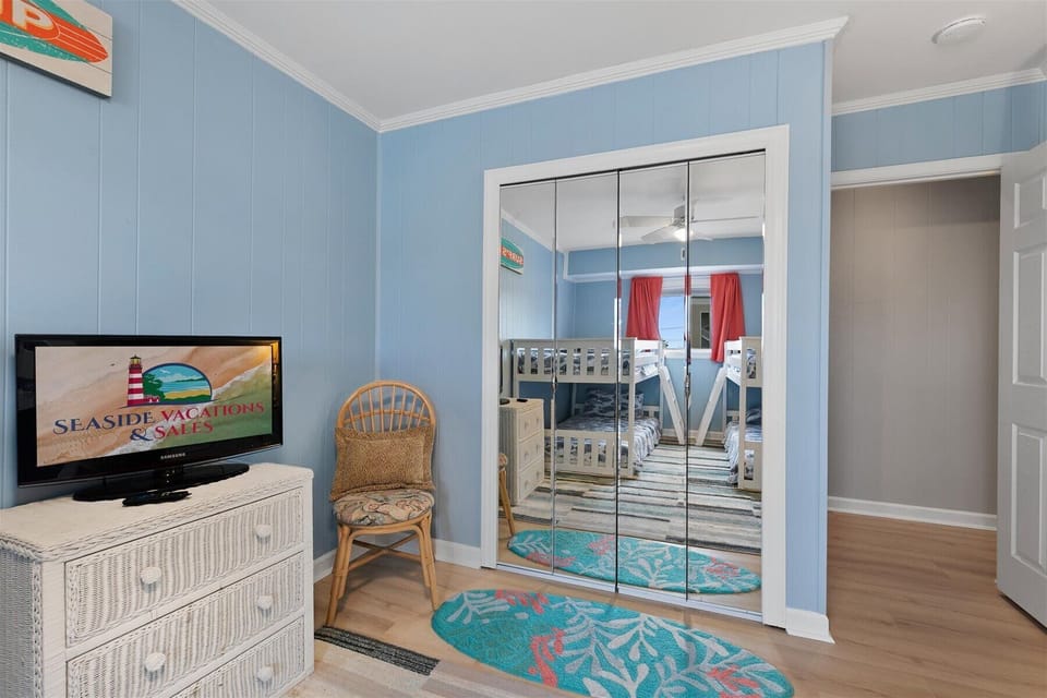 The bunk room includes a flatscreen TV for entertainment and large mirrored closet doors that make the space feel extra open.