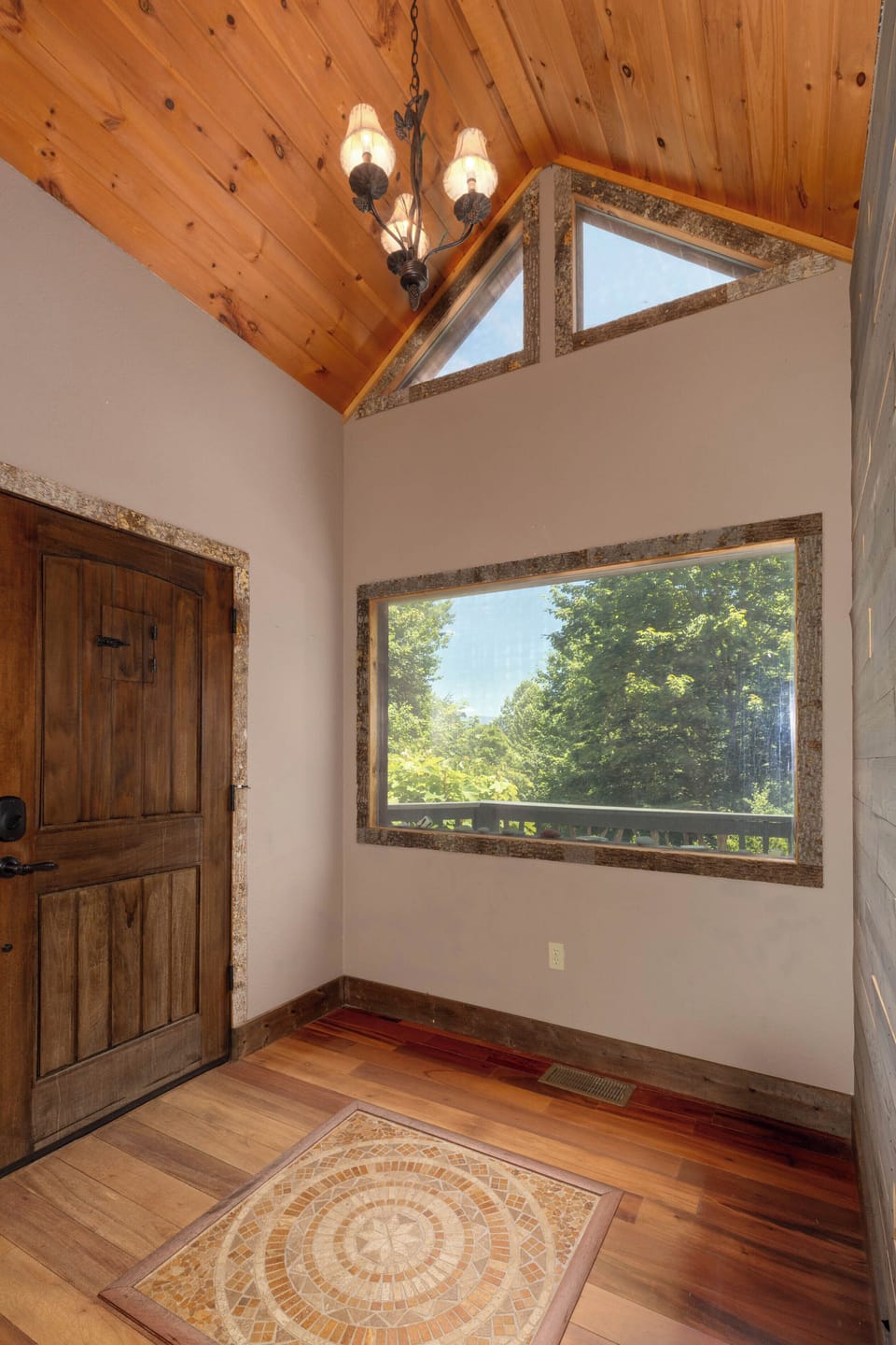 Entry Foyer - Bright foyer with vaulted wood ceiling and a wide view of the tree line.