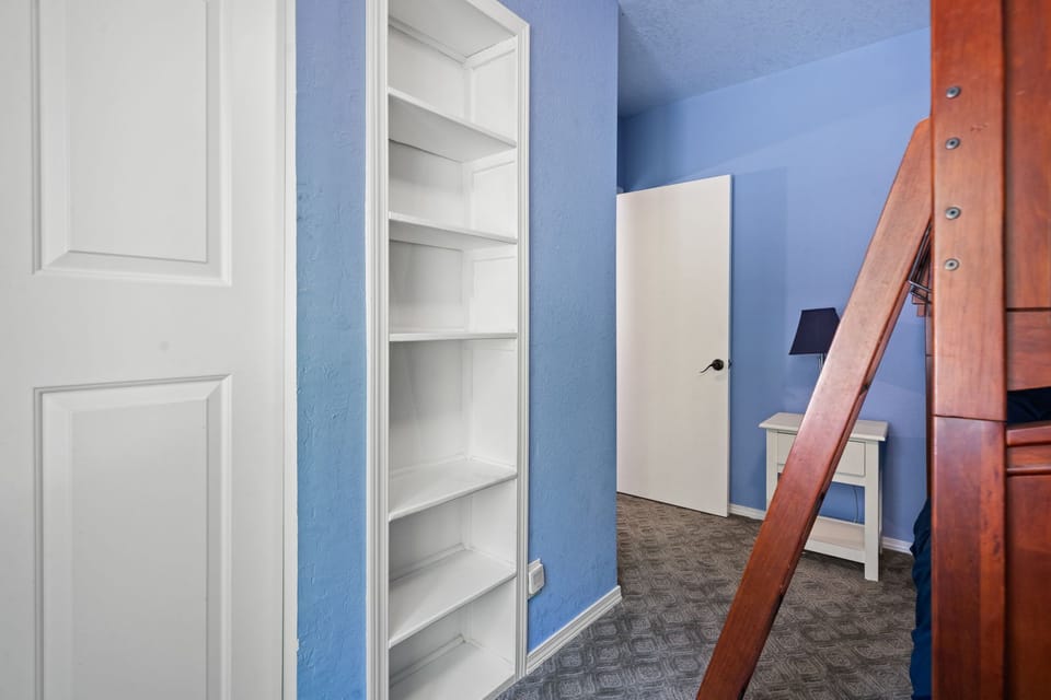 Built-in shelving and a ladder make the bunk room a hideaway of its own.