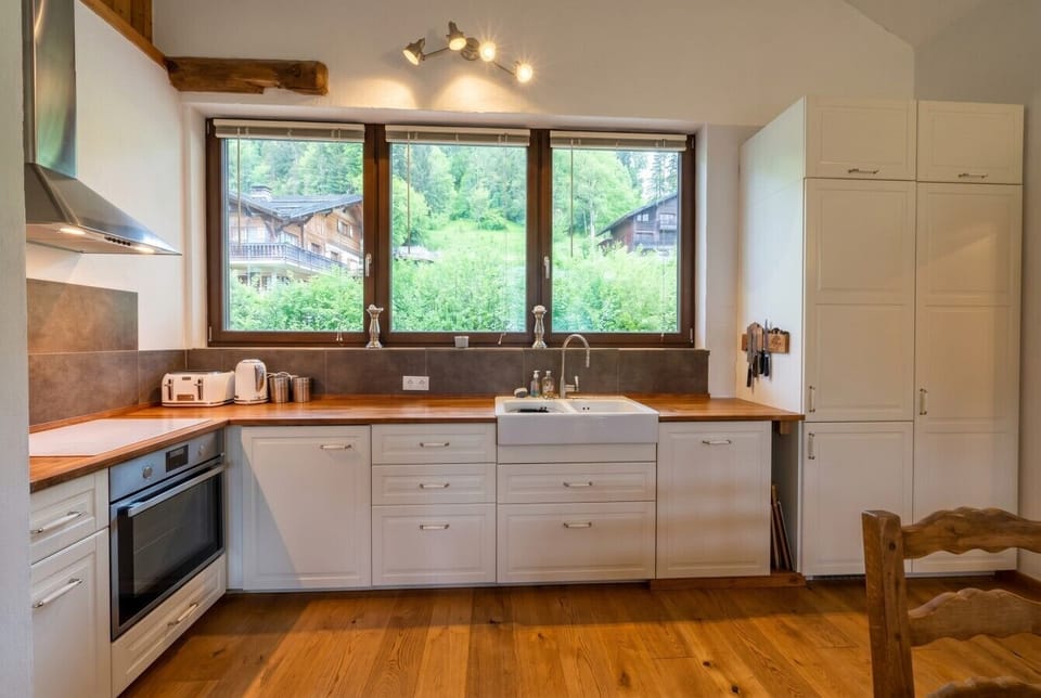 Whip up dinner in this spacious kitchen framed by chalet and forest views.
