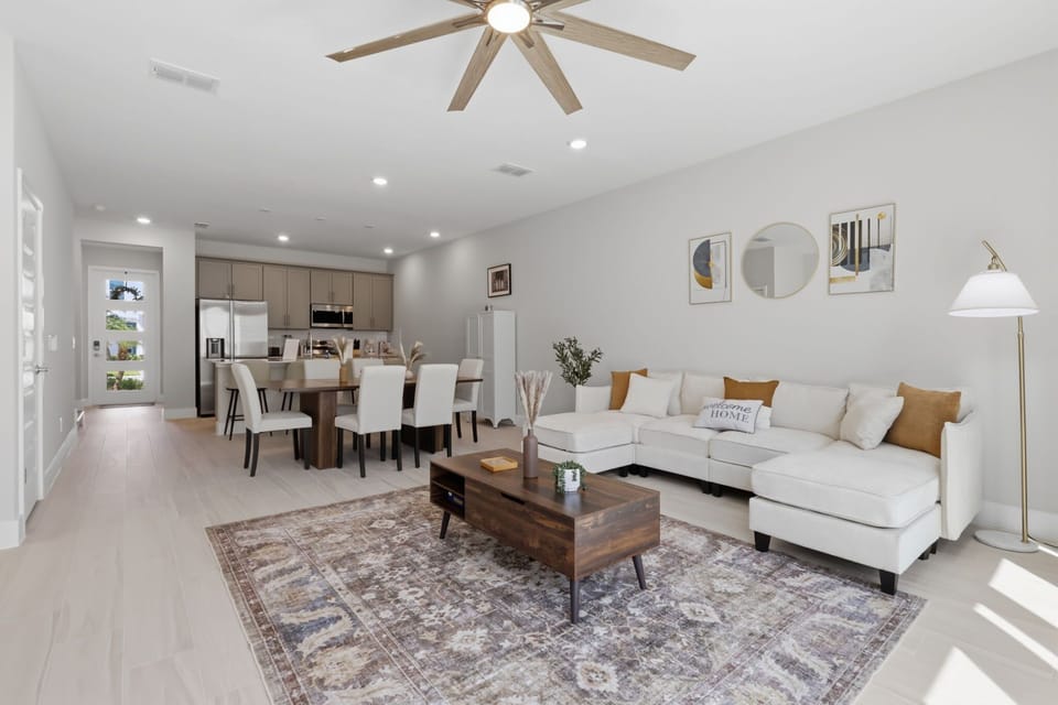 Open living area featuring an oversized ceiling fan, arcade game, and Smart TV.