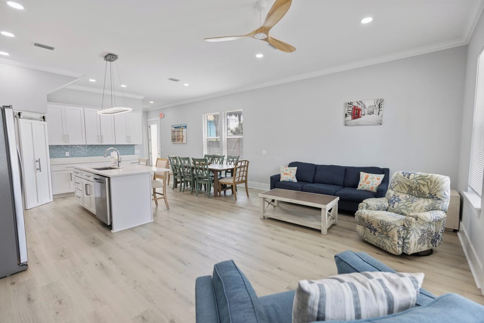 Bright open living, dining & kitchen with plush seating and natural light.