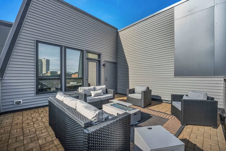 Modern rooftop patio with comfortable seating and a fire table for relaxing outdoors.