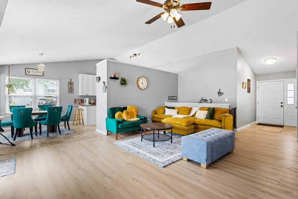 Relax in the open-concept living room featuring a cozy sectional, accent chair, Smart TV, fireplace, and direct access to the backyard deck—perfect for spending quality time together.