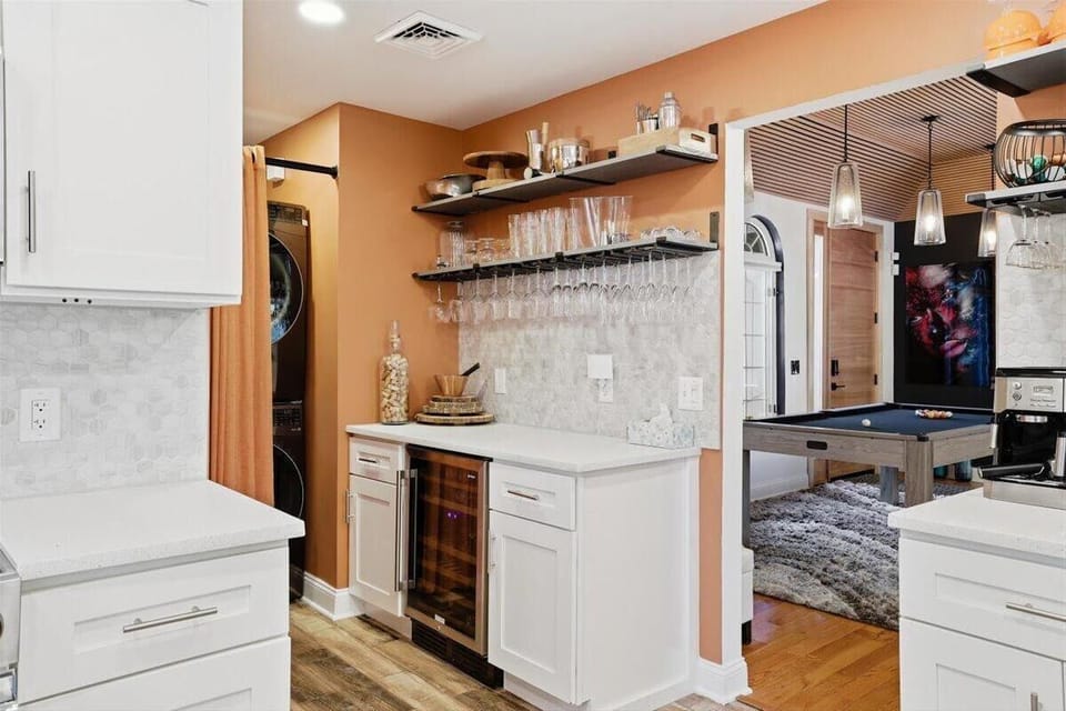 Pour a glass at the wet bar — the wine fridge is right there and the stemware hangs where you'll reach for it.