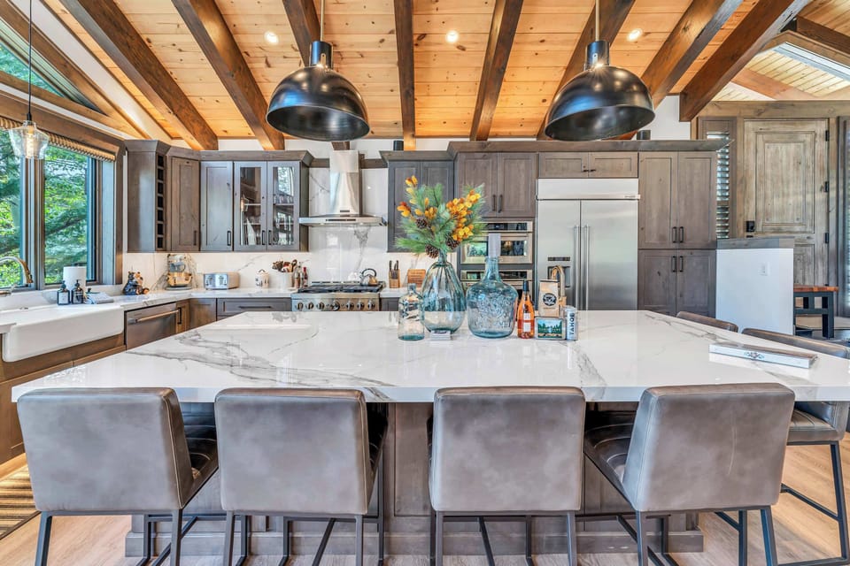 Kitchen area featuring stainless steel appliances and an island with seating for 6.