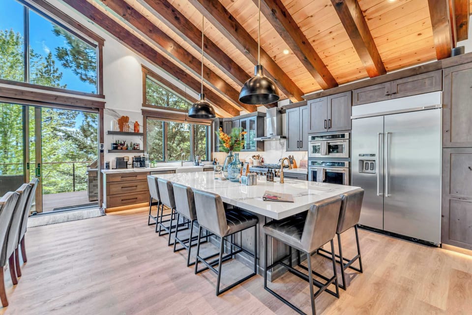 Kitchen area featuring stainless steel appliances and an island with seating for 6.