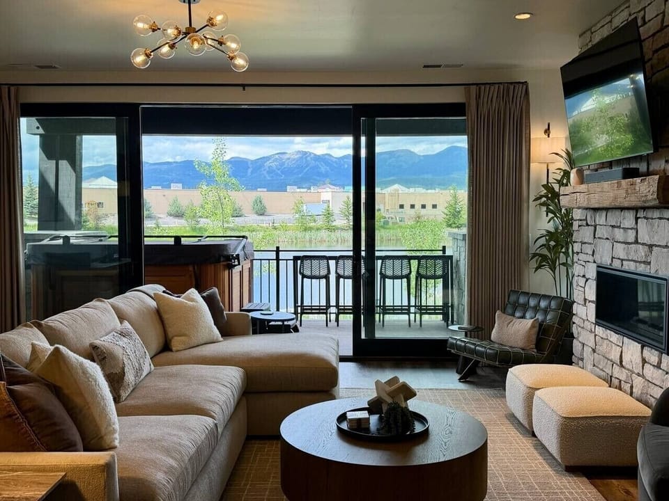 Snowghost Social includes a cozy living room with plush seating, floor-to-ceiling glass, and relaxing water views.