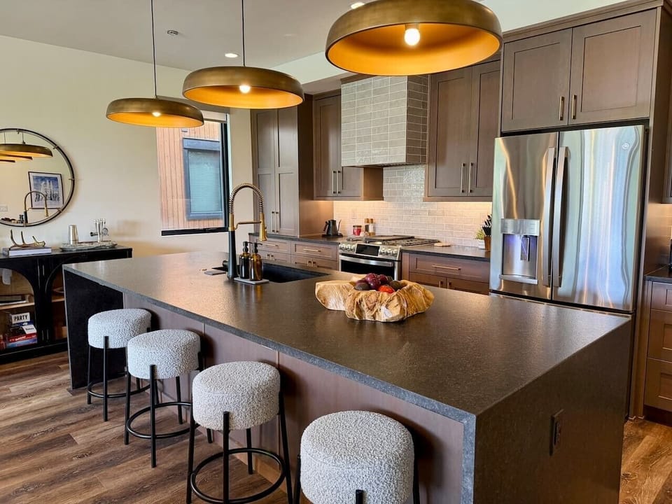 Snowghost Social offers a modern kitchen with a large island, bar seating, pendant lighting, and a polished entertaining setup.