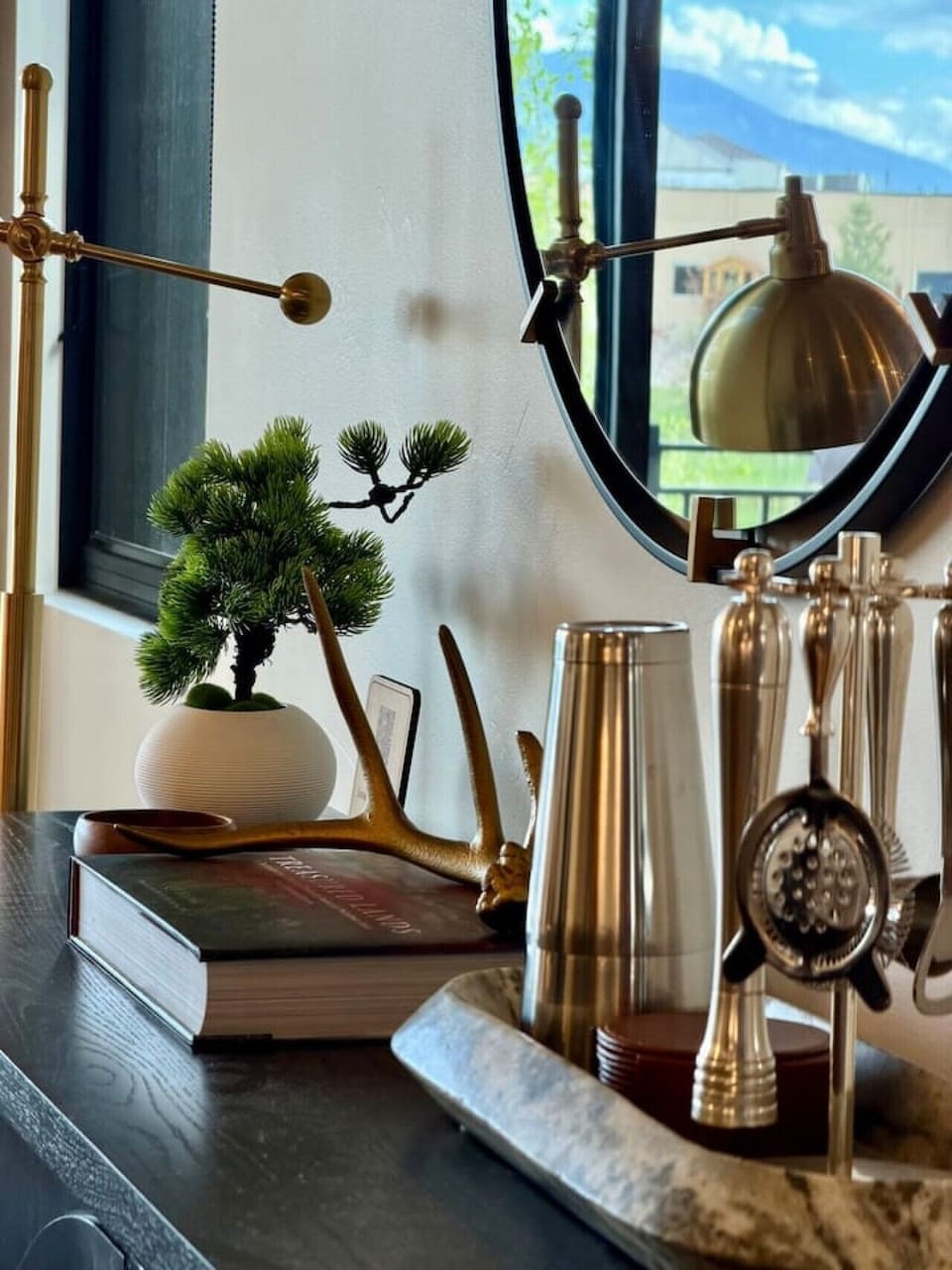 Snowghost Social highlights elevated decor with brass accents, curated books, greenery, and polished mountain-modern styling.