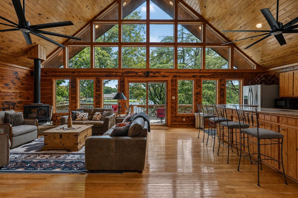 Vaulted lakeview great room with wall-to-wall windows and cozy lodge charm