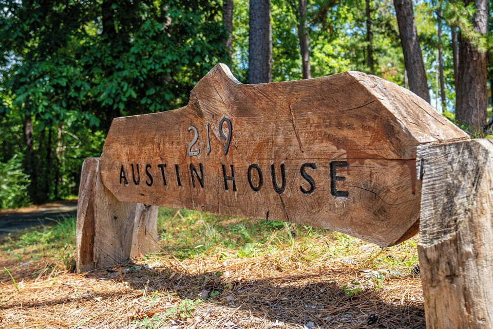 Rustic Austin House sign welcomes guests to a peaceful wooded retreat
