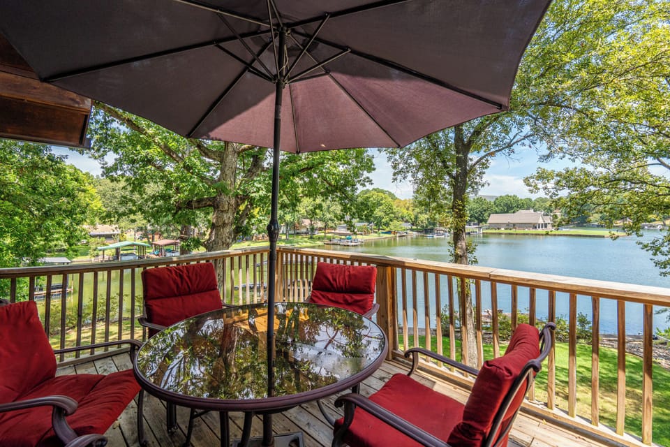 Shaded lakeside deck with dining for four and serene water views