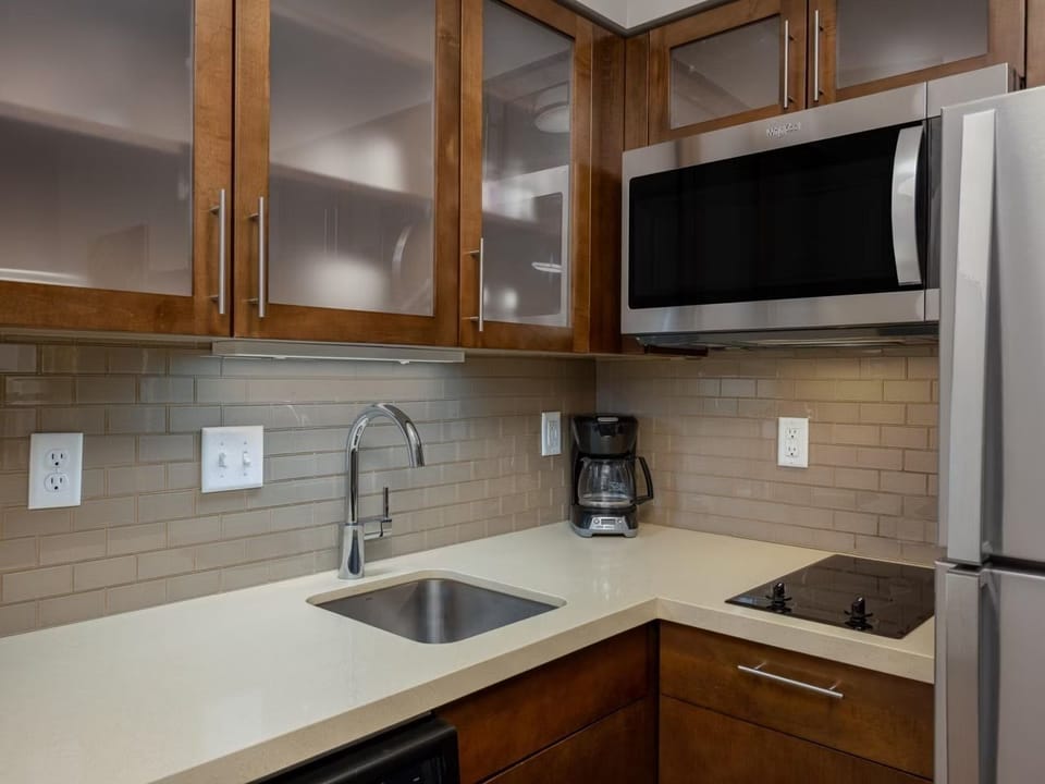 The fully equipped kitchen includes a stove, microwave, sink, and coffee maker.