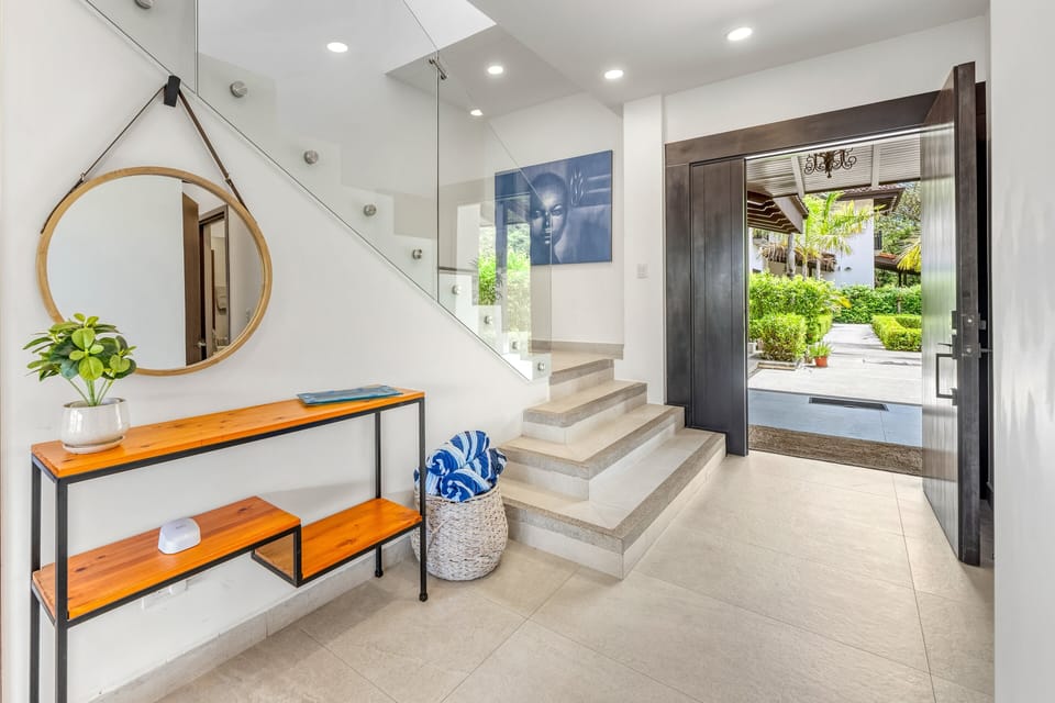 A glass-railed staircase and bold artwork make a striking first impression in this modern foyer. Mediterranean architecture meets contemporary Costa Rican style.