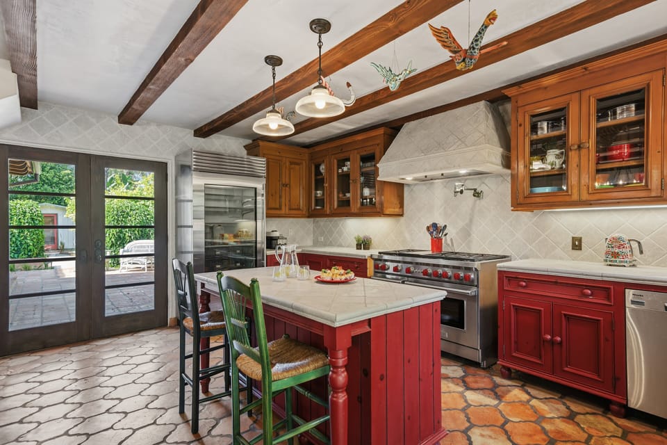 Spacious kitchen with stainless steel appliances, island with seating for 2, and cooking essentials.