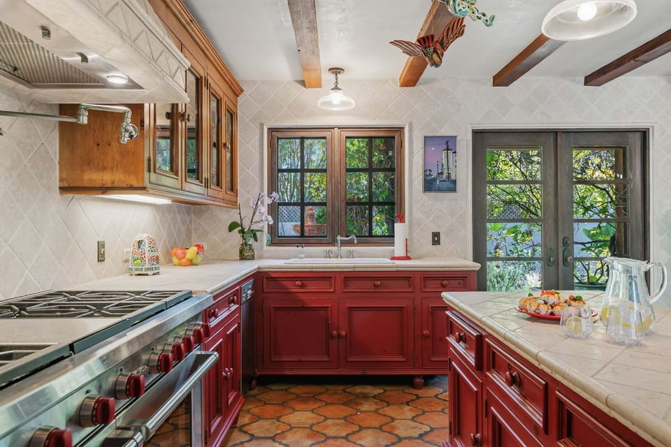 Spacious kitchen with stainless steel appliances, island with seating for 2, and cooking essentials.