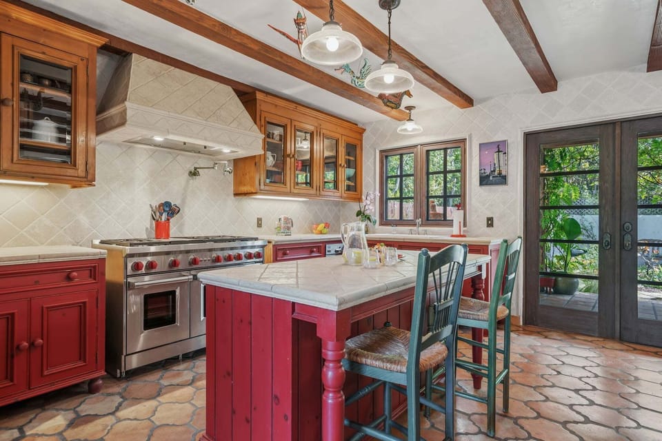 Spacious kitchen with stainless steel appliances, island with seating for 2, and cooking essentials.