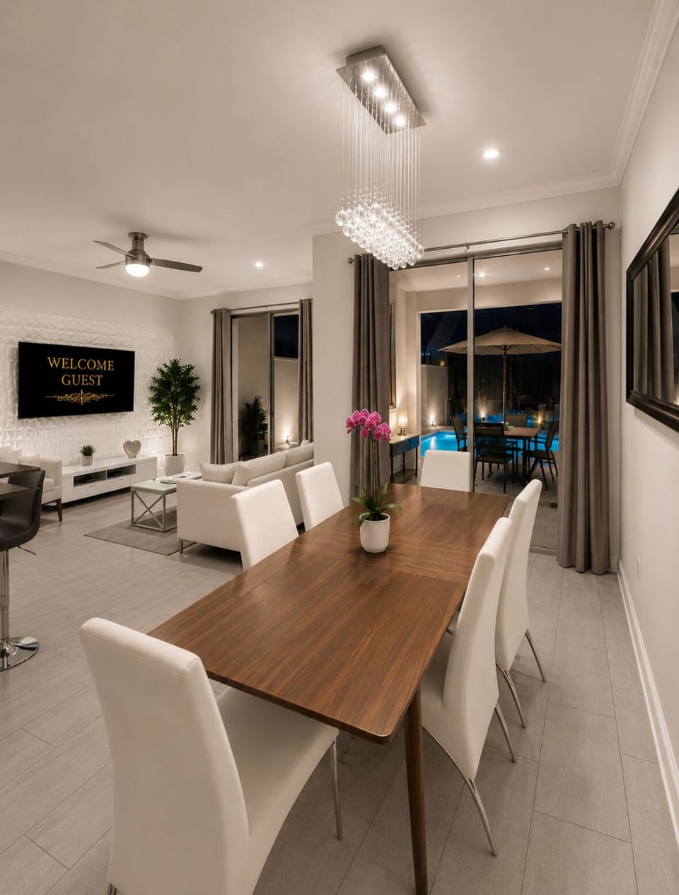 Modern open-plan dining and lounge with pool views and elegant lighting